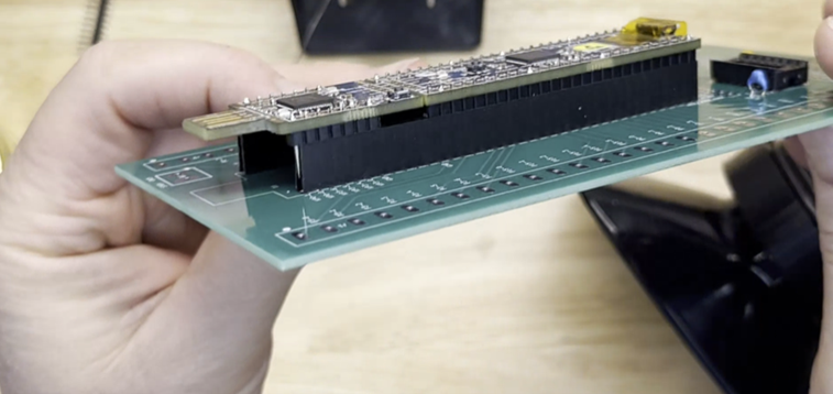 Showing male and female headers held in alignment with PSoC Dev board